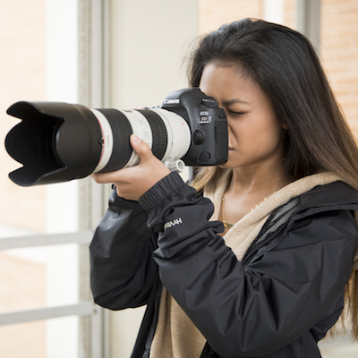 Female student using long lens camera