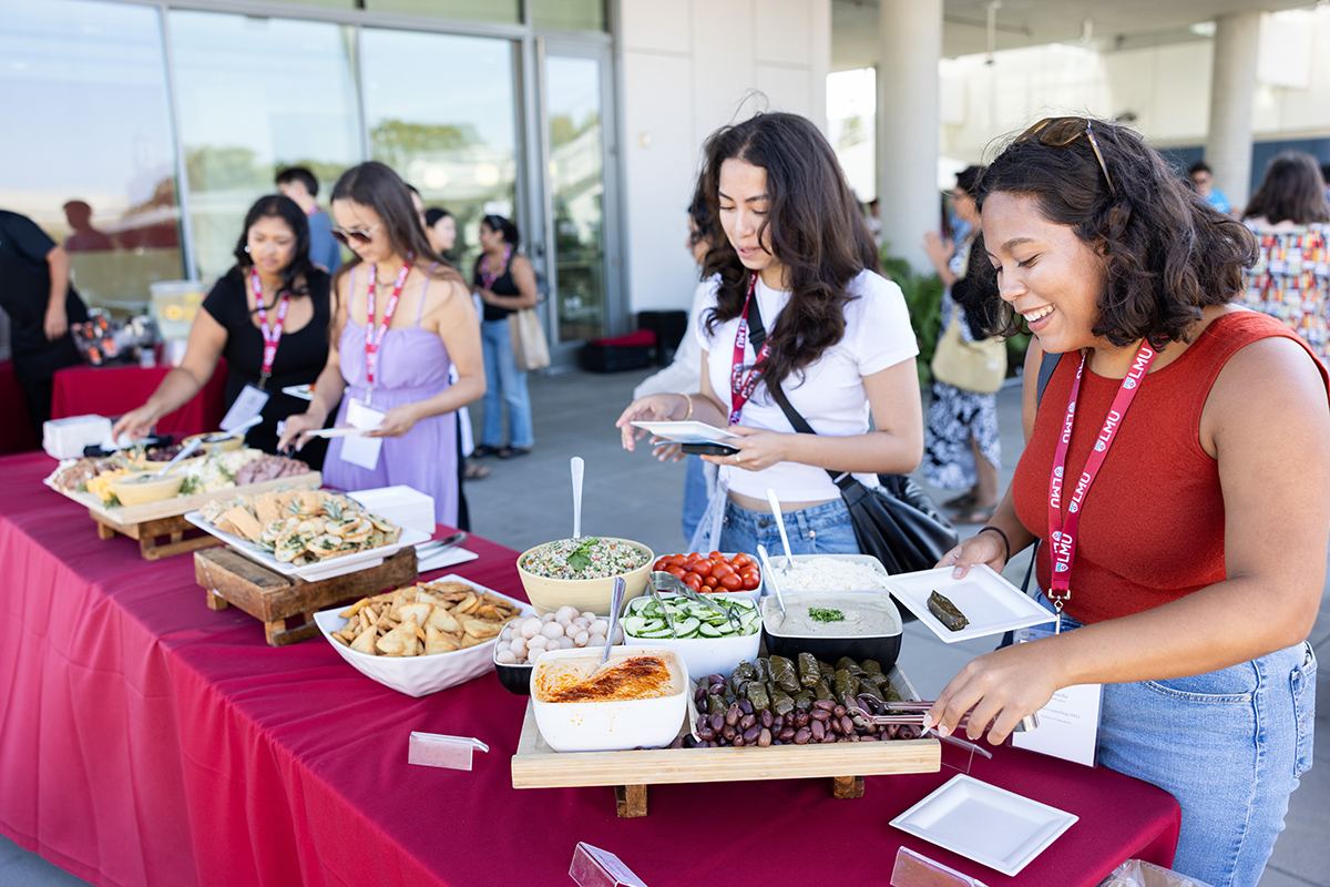 Four Graduate students getting food at a student government mixer
