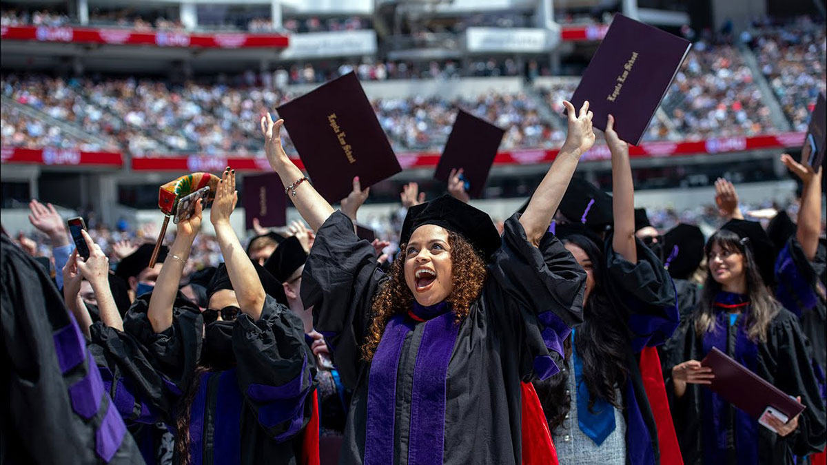 All graduates standing and cheering with the SoFi Stadium stands erupting with applause from family and friends
