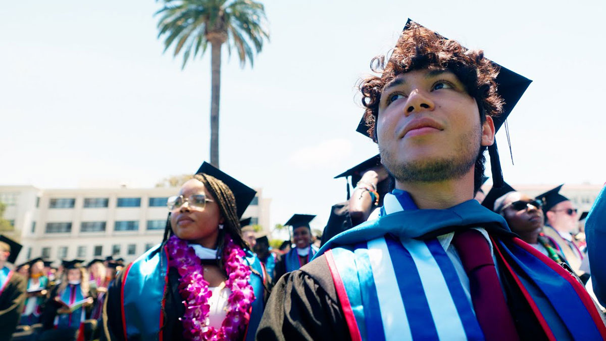 Graduates standing at their seats before the start of commencement