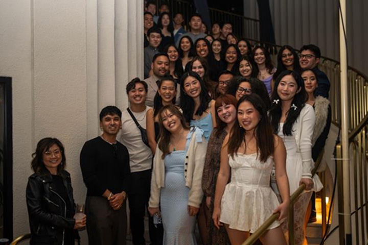 Graduating students in dress attire lined up along a winding staircase