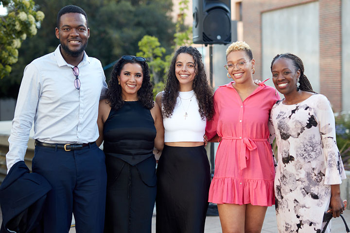 A family standing with their graduate and smiling