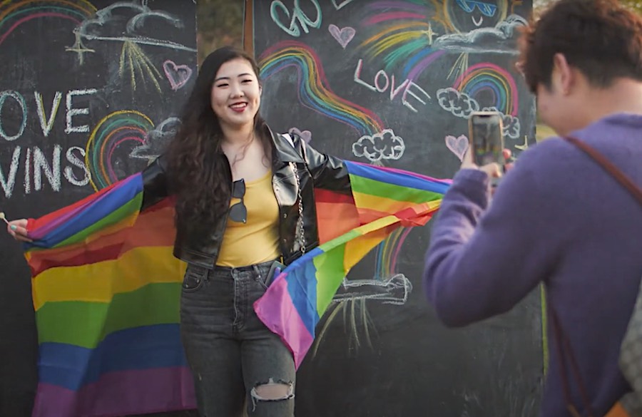Woman posing with rainbow a flag wrapped around her